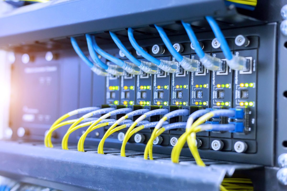 Network switch with blue and yellow Ethernet cables in a rack